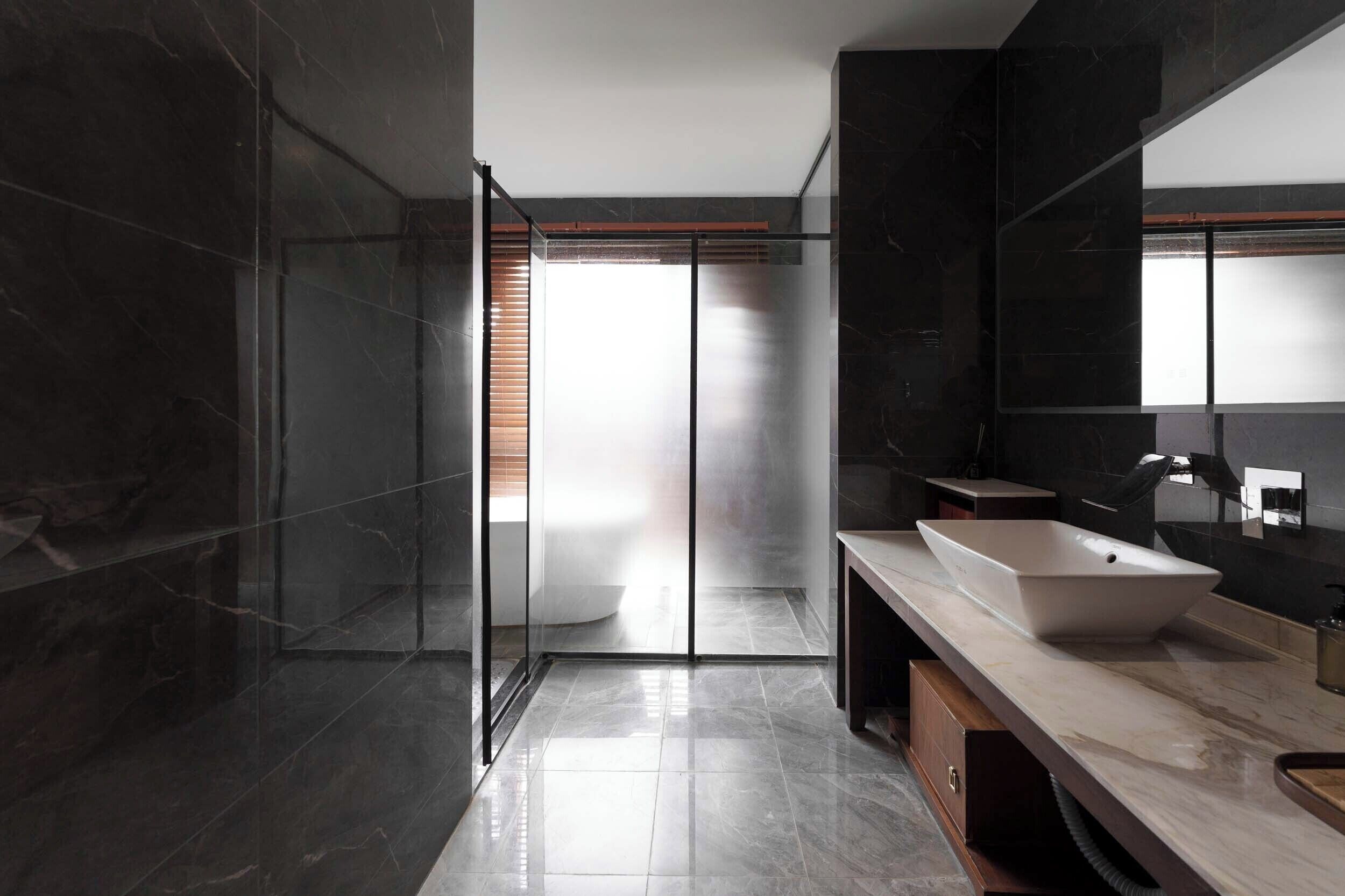 Un bagno moderno con un grande specchio, un lavabo a incasso e cabina doccia in vetro.