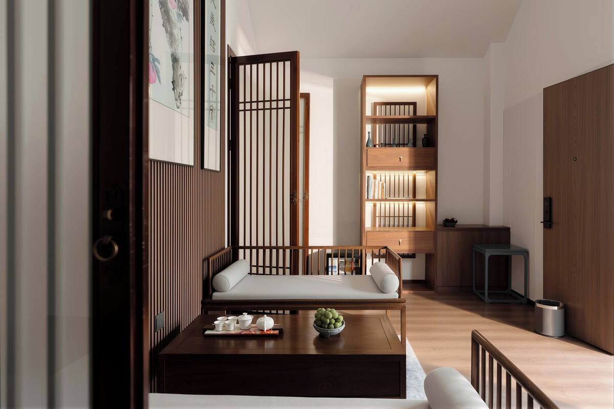 Un interior moderno con un sofá, una mesa de centro, una estantería y un separador de madera.