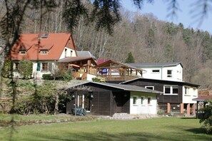 A multi-story building with a red roof, a balcony, and a covered area. - Holiday home with 2 bedrooms (Porschdorf)