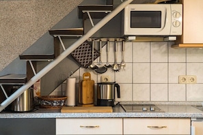 A kitchen with a microwave, kettle, and various utensils on the counter. - Merle in Plau - Heidenholz (Plau am See)