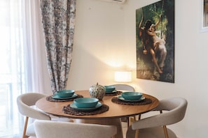 Ein Esstisch mit vier türkisfarbenen Schüsseln, einer dekorativen Vase und einem Bild an der Wand.