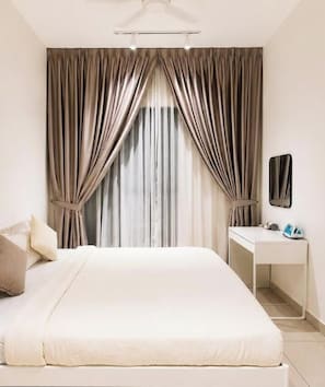A bedroom with a bed, a desk, and curtains. - Iconic Elevated Suite at Trion (Kuala Lumpur)
