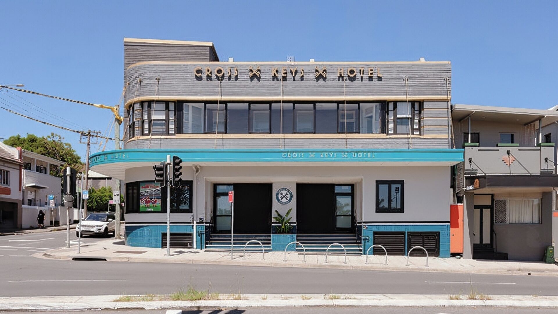 A two-story building with a sign that reads 'CROSS KEY HOTEL.'