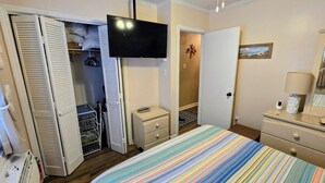 Camera d'albergo con un letto, una TV, un guardaroba, una cassettiera e una ventola a soffitto.