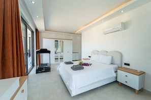 A modern bedroom with a bed, bedside tables, an air conditioning unit, and a view through a window. - Just 500 Meters to the Beach: Sea View, Private Pool, 10-Guest Villa in Kışla (Antalya)
