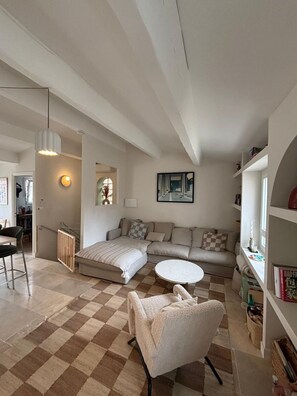 A living room with a sofa, a round coffee table, a chair, a radiator, and a bookshelf. - Endoume - Town house 140 m² - Large terrace & private garage (Marseille)