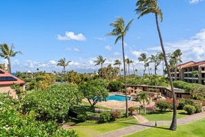 Ein Resort mit Pool, Palmen und einem Gebäude mit rotem Dach.