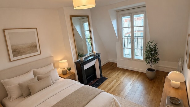 A bedroom with a bed, a fireplace, a window, and a plant. - COSY, FULLY-EQUIPPED APARTMENT (Paris)