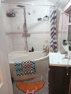 Ein Badezimmer mit Badewanne, Dusche und Waschbecken.