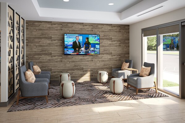 Eine moderne Lobby mit großem Fernseher, bequemen Sitzgelegenheiten und einer Holzwand.