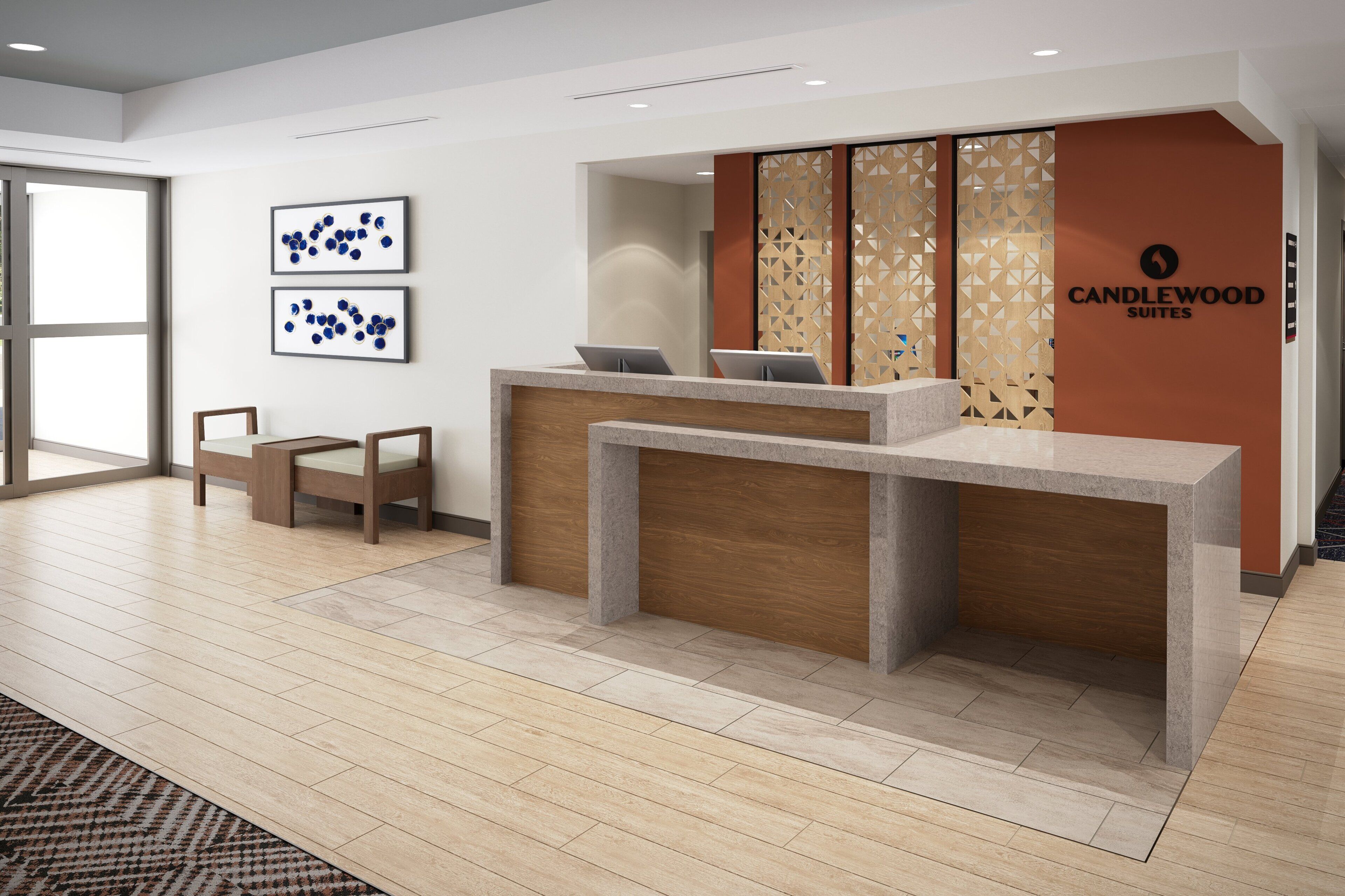 A reception desk with two chairs, a wooden accent wall, and a geometric patterned wall.