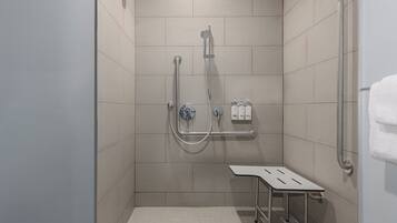 Un espace douche équipé d’un pommeau de douche à main, d’un autre pommeau de douche à main et d’un troisième pommeau de douche à main.