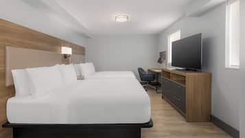 Habitación de hotel moderna con una cama grande, un escritorio, una silla, un televisor y una ventana.