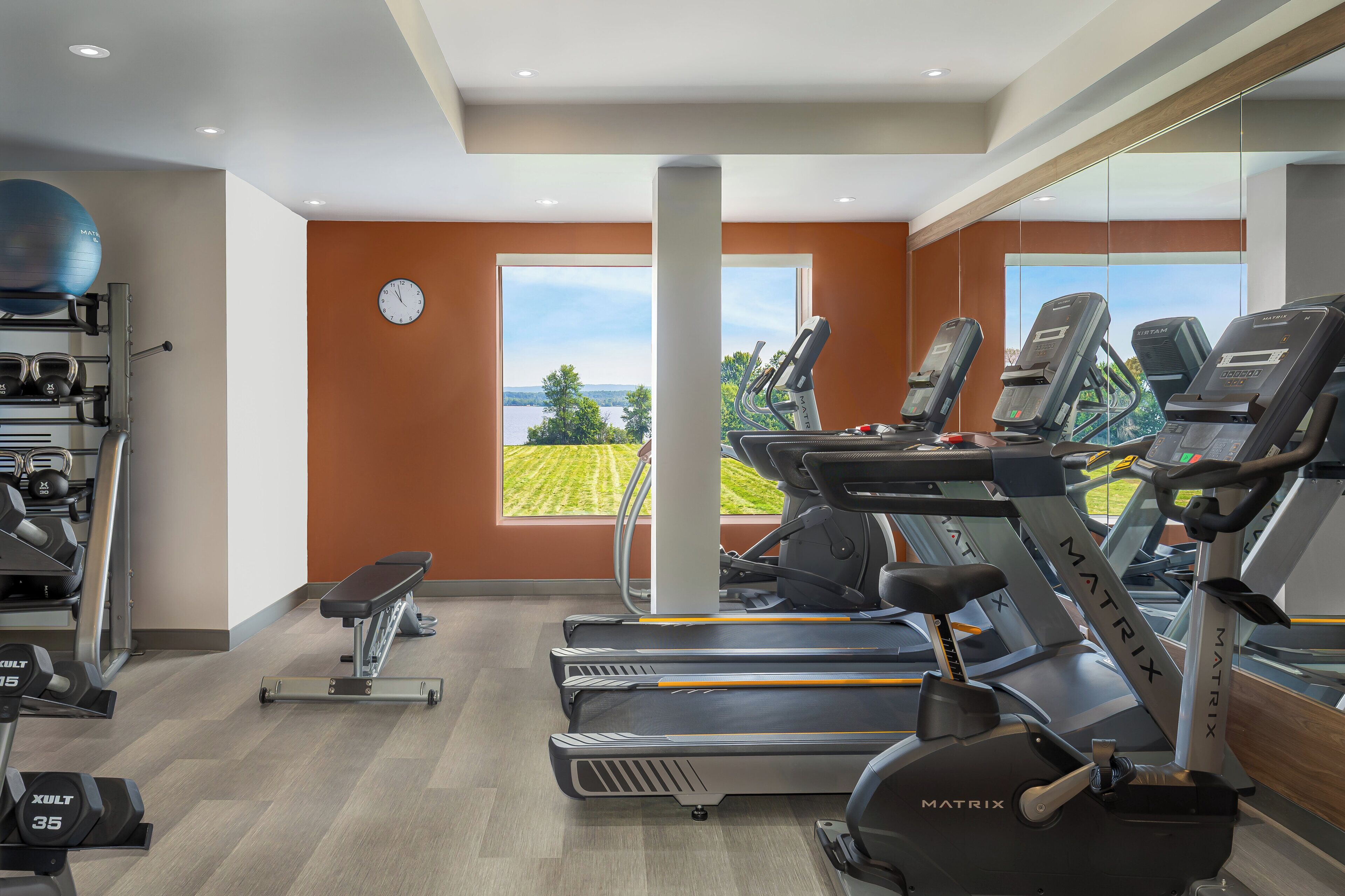 A gym with treadmills, exercise balls, and weights.