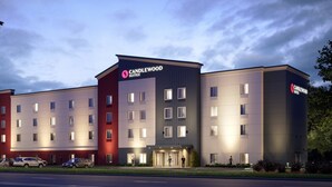 Um hotel com vários andares e design moderno, com um destaque para a placa 'CANDLEWOOD SUITES'.