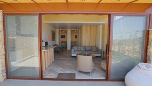 Amplia sala de estar con sofá, mesa de centro y puerta corrediza de vidrio que da a un patio al aire libre.