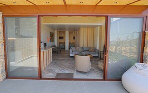 Amplia sala de estar con sofá, mesa de centro y puerta corrediza de vidrio que da a un patio al aire libre.
