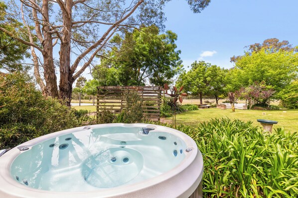 Un jacuzzi rodeado de vegetación exuberante y árboles.