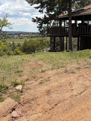 A wooden deck with a view of a rural landscape.