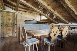 Ein rustikales Holzinterieur mit einem Holzesstisch, Stühlen und einem Teleskop.