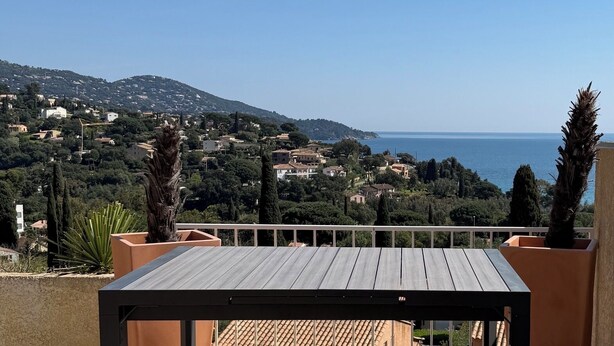 Una terrazza con vista su una località costiera e il mare.