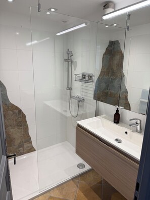 A modern bathroom with a glass-enclosed shower, a white sink with a wooden vanity, and a large mirror. - Beautiful Mazet in Pramousquier, Le Lavandou, with Terrace, 3 Bedrooms Sea View. (LE LAVANDOU)