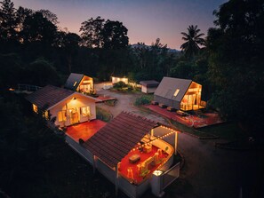 Ein modernes Resort mit mehreren Gebäuden, Außenbereichen zum Sitzen und einem gut beleuchteten Weg.
