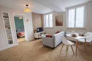 Un salon moderne avec un canapé, une table à manger et un téléviseur.