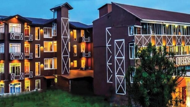 A multi-story hotel with balconies, a central courtyard, and a sign indicating a restaurant. - Queensbury City Hotel - Nuwaraeliya (Nuwaraeliya)
