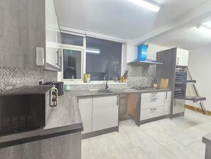 A modern kitchen with a large window, a built-in oven, and a gas stove.