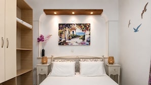 Ein Schlafzimmer mit einem Bett, zwei Nachttischen, einem Schrank und einem Bild an der Wand.
