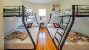 Un dormitorio con literas, una mesita y una ventana.