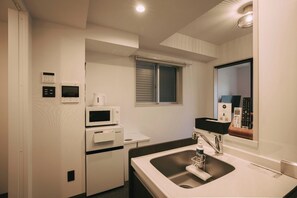 A compact kitchenette with a microwave, kettle, and small refrigerator. - LIFEMENT GLANZ SAKAIMACHI (Hiroshimashi nakaku sakaimachi)