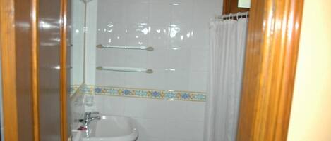 A bathroom with a sink, mirror, and towel rack.