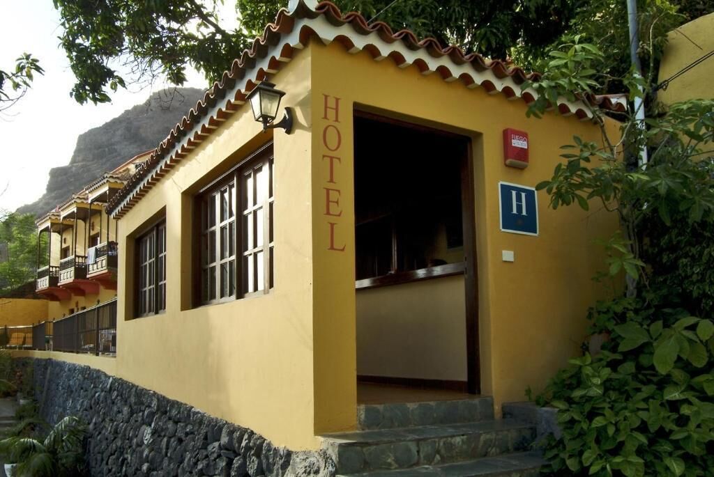 A yellow building with a sign reading 'HOTEL' and a wheelchair accessibility symbol.