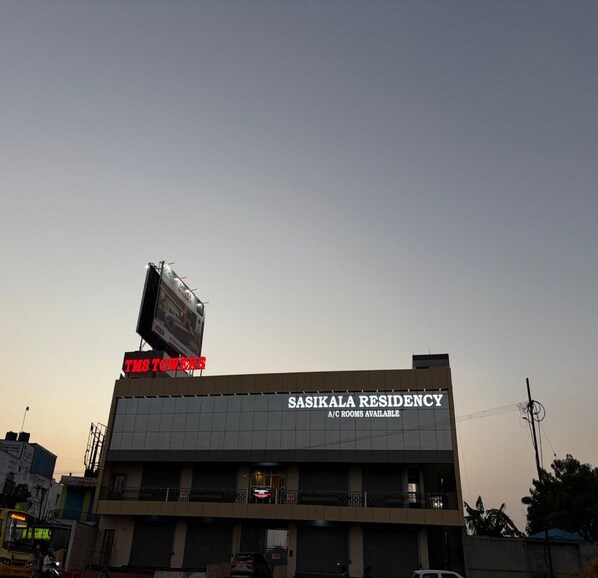 Un edificio con un cartello che indica 'TMS TOWERS' e 'SASIKALA RESIDENCY', segnalando la disponibilità di camere climatizzate.