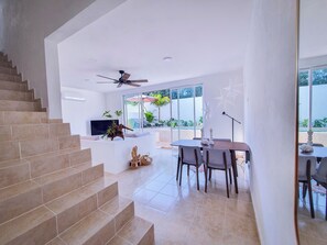 Ein modernes Interieur mit Treppe, Essbereich und Deckenventilator.