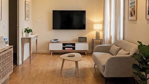 A modern living room with a flat-screen TV, a sofa, a coffee table, and a side table with a lamp. - The roch annex (Saint-Pierre-Quiberon)