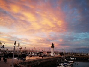 A harbor with a lighthouse, boats, and a pier with people and bicycles. - The roch annex (Saint-Pierre-Quiberon)