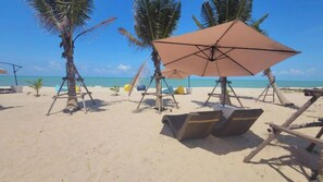 Pantai pribadi, kursi berjemur, payung pantai, dan handuk pantai