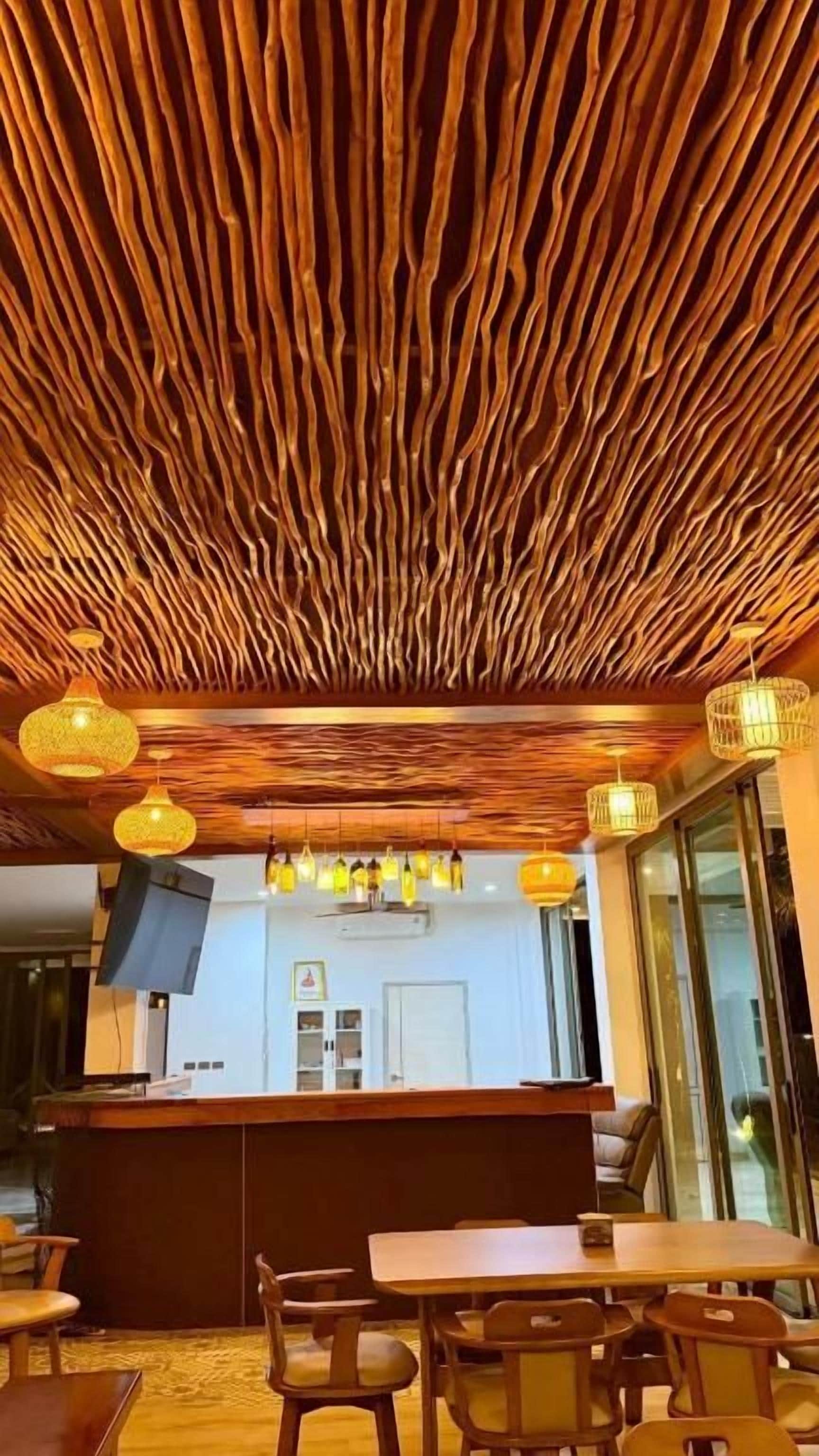 A restaurant interior with a wooden ceiling, a bar area, and seating arrangements.