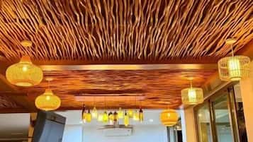A restaurant interior with a wooden ceiling, a bar area, and seating arrangements.
