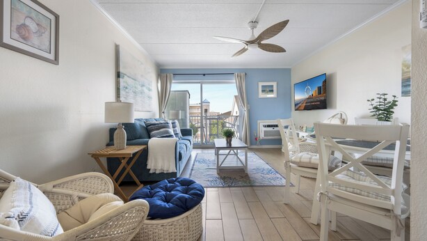 A room with a ceiling fan, wicker furniture, a sofa, a coffee table, and a view through a glass door. - Just listed for rent! Oceanview condo in an oceanfront building with a pool, elevator and assigned parking (Ocean City)