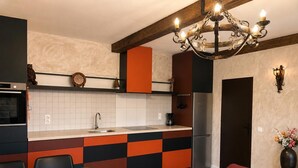 A modern kitchen with a central island, a built-in oven, and a refrigerator.