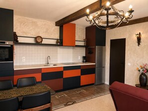 A modern kitchen with a central island, a built-in oven, and a refrigerator.