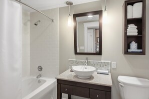 A bathroom with a bathtub, a sink, a toilet, a mirror, and a towel shelf. - Studio in Elation at Sandestin Golf and Beach Resort! (Miramar Beach)