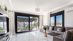Een moderne woonkamer met een bank, een salontafel en een grote schuifdeur naar een terras.