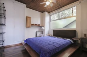 A bedroom with a bed, a ceiling fan, a window, and a shelf. - Cozy and central apartment near Plaza del Sol (Freses)