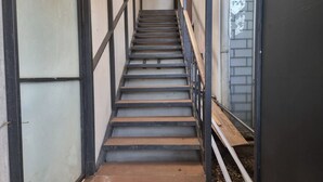 Eine Treppe mit Metallgeländern und Holzstufen.