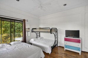 Quarto com beliches, televisão e cômoda.